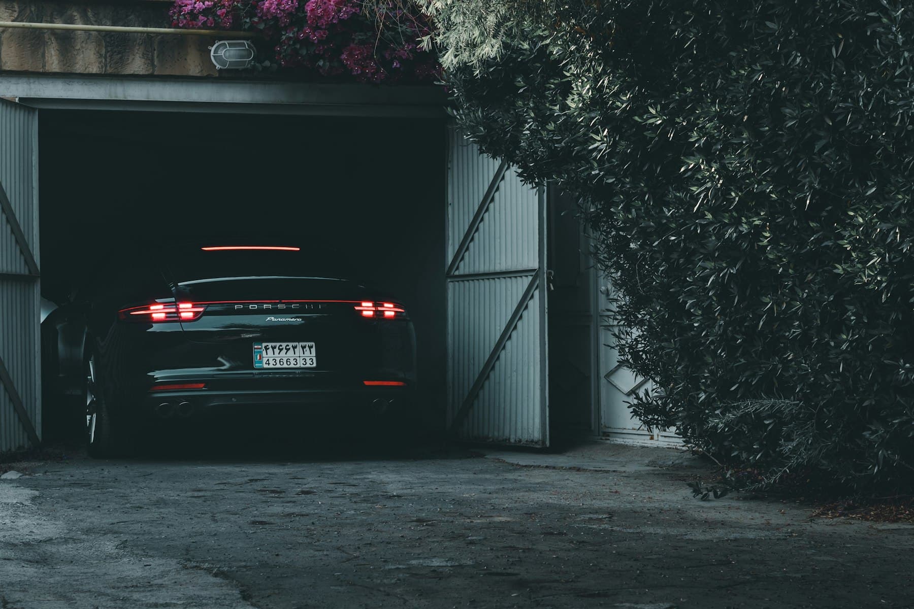 Black Porsche parked in a residential garage at dusk